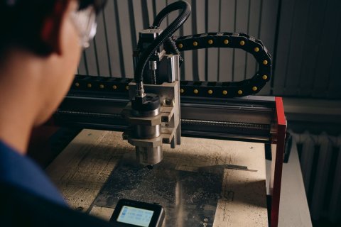工作機械の前で作業する人の後ろ姿