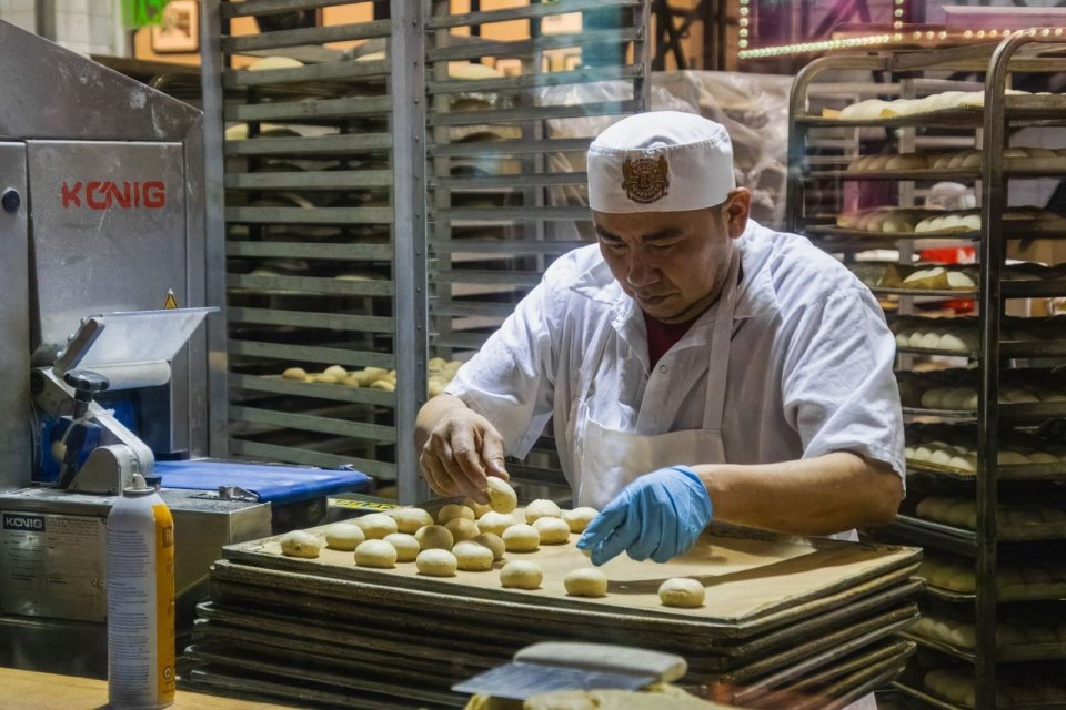 製パンの作業場で、パン生地を整える人
