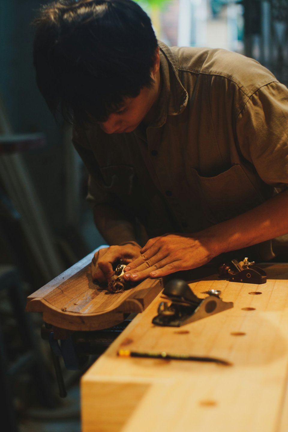作業台で木材を削る職人の横顔